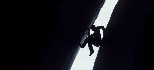 climber finding a path up a cave crevass